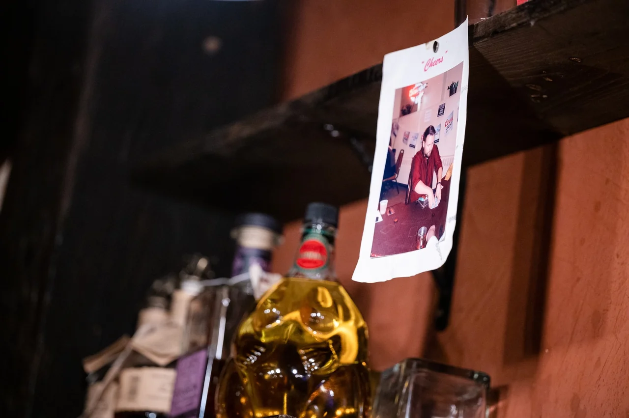 Whiskey old-fashioned garnished with a twist on a walnut bartop